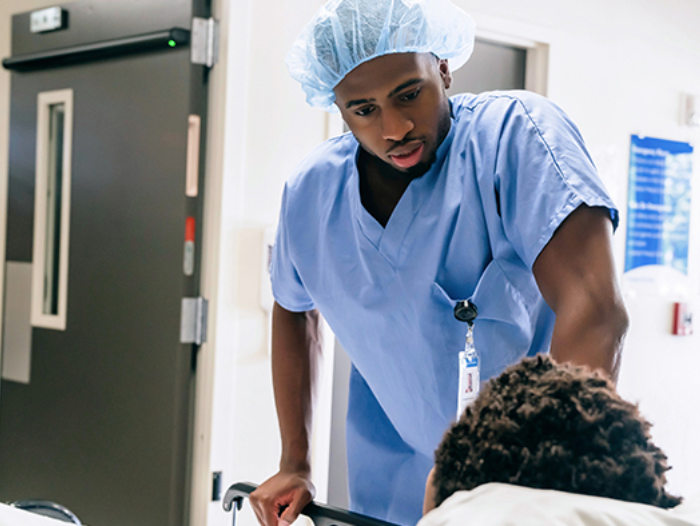 A surgeon talks to a patient in a hospital bed