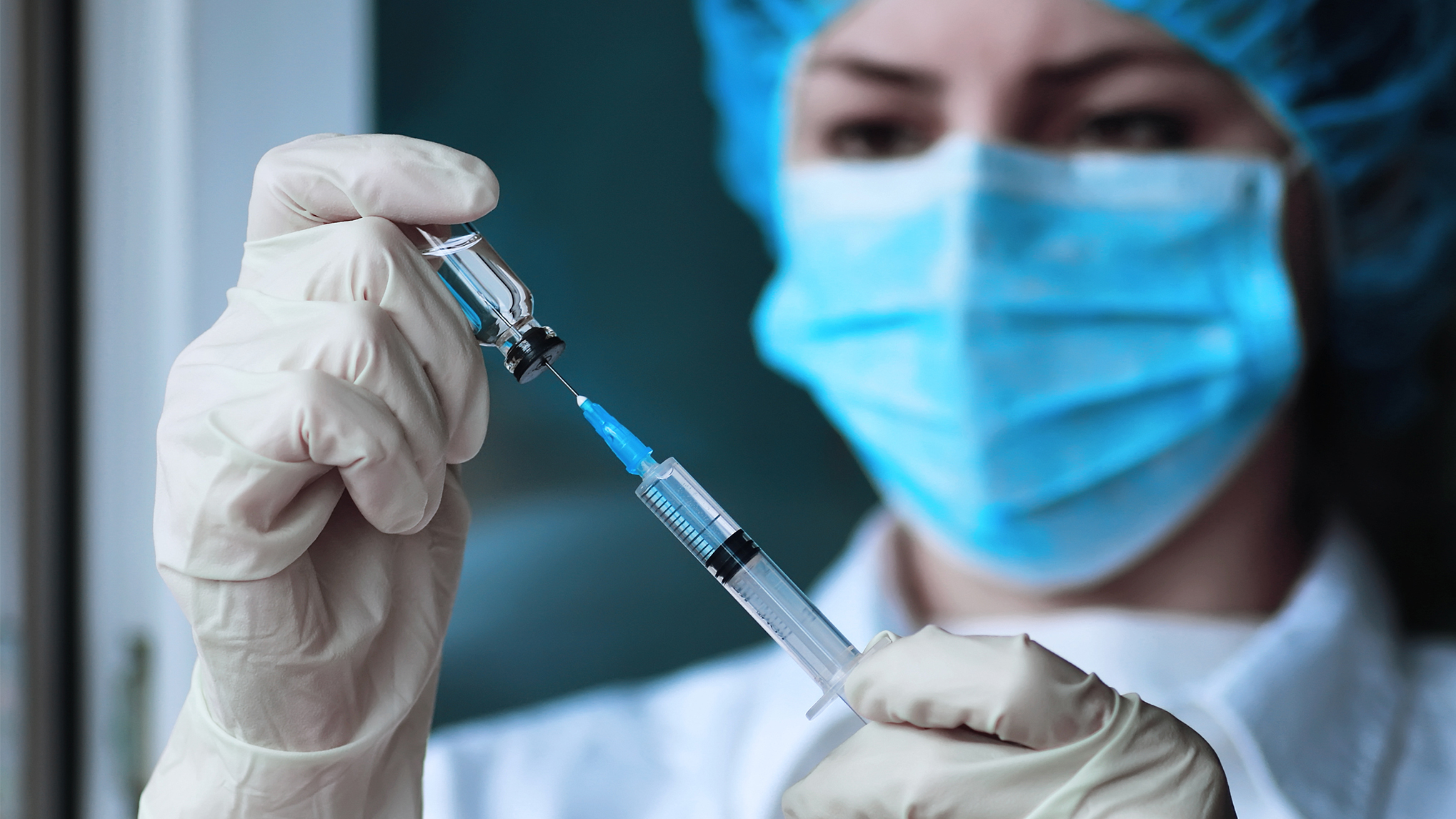 Woman filling needle with vaccine